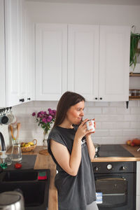 Young woman drinking drink at home