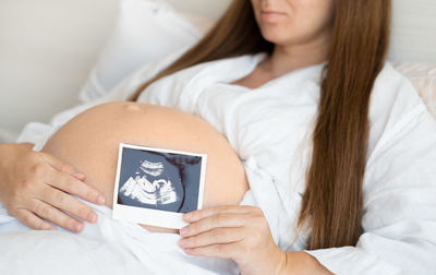 Midsection of female doctor examining patient