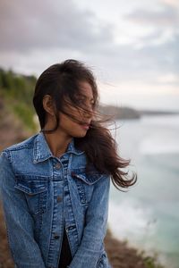 Beautiful woman standing against sea against sky