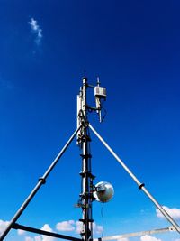 Low angle view of communications tower against clear blue sky