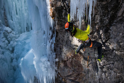 Man climbing on frozen mountain