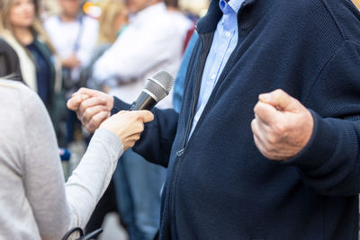 Journalist making media or vox pop interview with unrecognizable person