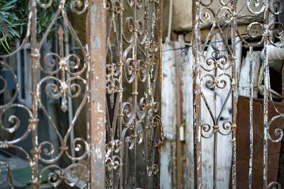 Close-up of metal gate against old building