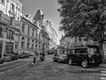 Cars on road by buildings in city