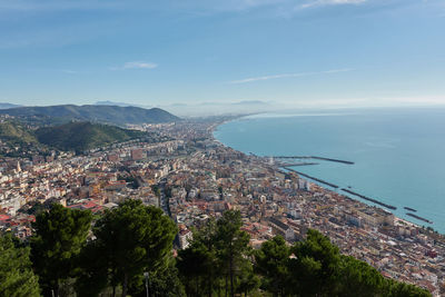 High angle view of townscape by sea against sky