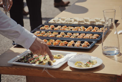 Midsection of person by food on table