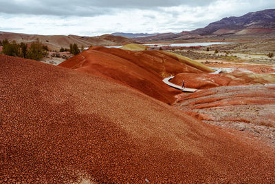 Wide view of woman walking on boardwalk at painted hills