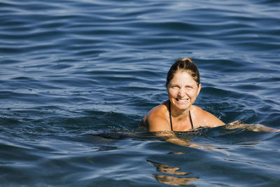 Portrait of smiling woman swimming in sea