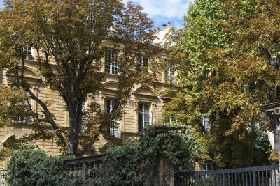 Low angle view of trees and building against sky