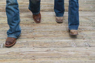 Low section of people standing on wooden floor