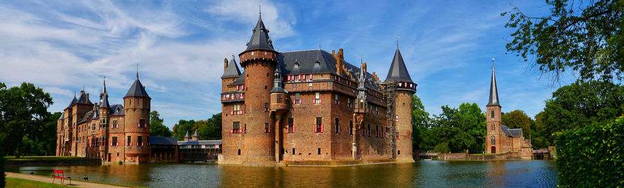 Panoramic view of buildings by river against sky