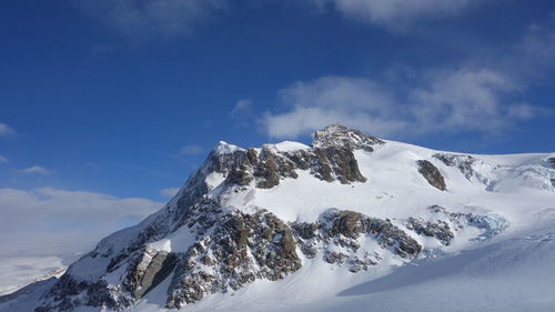 Low angle view of snowcapped mountain against sky