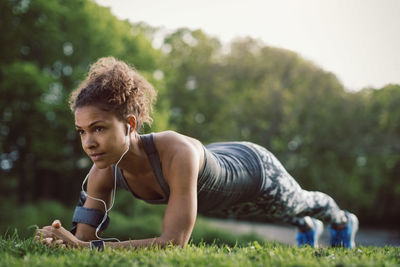 Sporty woman doing plank exercise at park