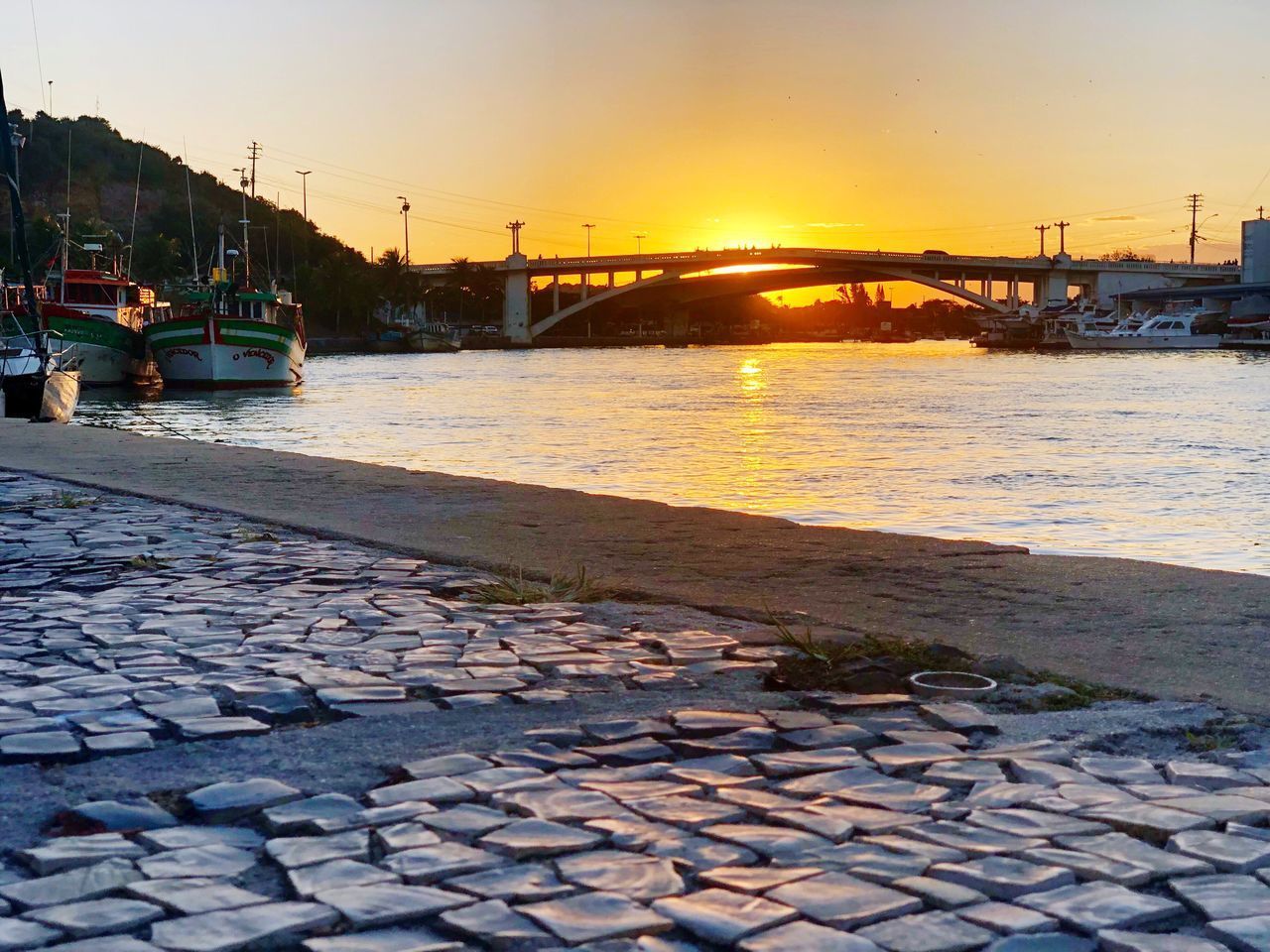 VIEW OF STREET BY RIVER AGAINST SKY