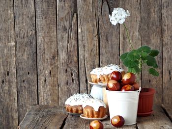 Painted eggs in a white bucket with easter cakes 