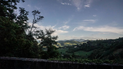 Scenic view of trees and mountains against sky