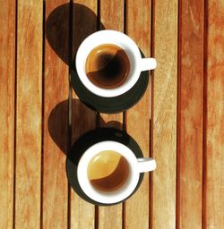 Directly above shot of coffee cups on wooden table