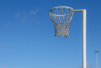 Low angle view of basketball hoop against clear blue sky