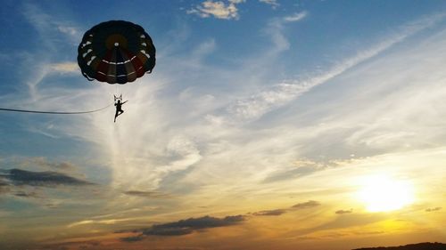 Low angle view of person parachuting against sky