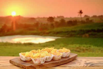 Close-up of cake on table against sky during sunset