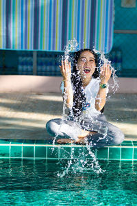 Full length of smiling woman in swimming pool