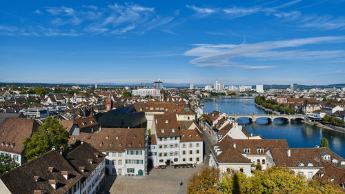 High angle view of buildings in city against blue sky