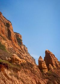 Rock formations on mountain against clear blue sky