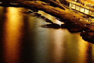 River by illuminated bridge at night