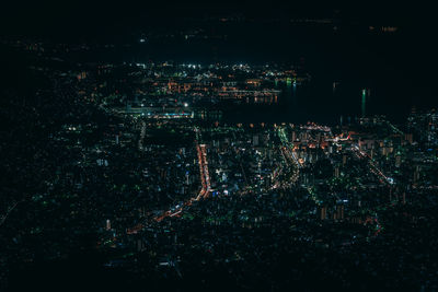 High angle view of illuminated city against sky at night