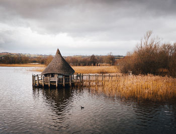 Built structure by lake against sky