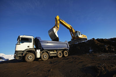 Earth mover filling dump truck