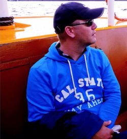 Man looking away while sitting outdoors