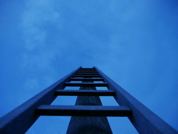 Low angle view of ladder leading towards blue sky at dusk