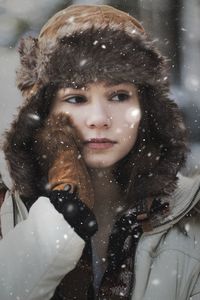 Woman looking away outdoors during snowfall