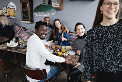 Cheerful multi-ethnic friends enjoying brunch at restaurant