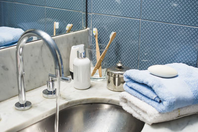 Cropped hand washing hands in bathroom