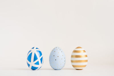 Three easter golden decorated eggs on white background. minimal easter concept. happy easter card 