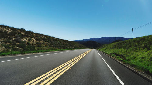 Empty road along countryside landscape