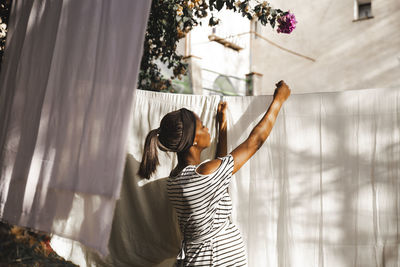 Pregnant woman hanging laundry in backyard