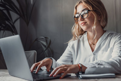 Portrait of young woman using laptop on table