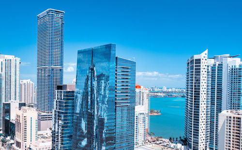 Modern buildings in city against blue sky