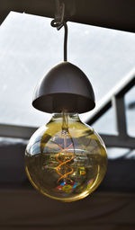 Close-up of light bulb hanging on table