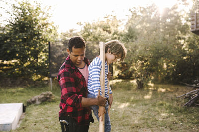 Young man standing against plants