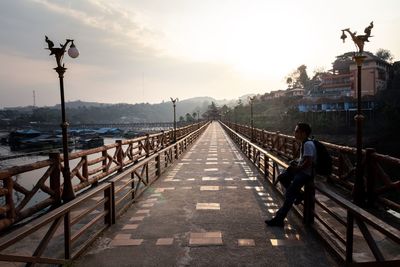 Full length of man standing by railing on footbridge