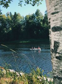 People by lake against trees