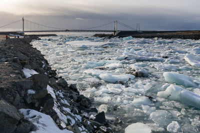 Bridge over river against sky during winter