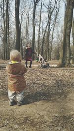 Rear view of people on street amidst trees
