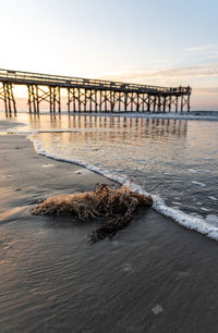 Pier over sea against sky during sunset