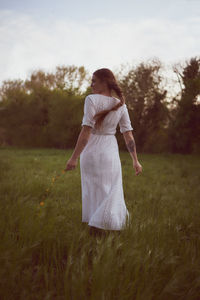 Woman with umbrella standing on field