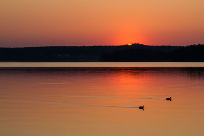 Scenic view of lake against orange sky